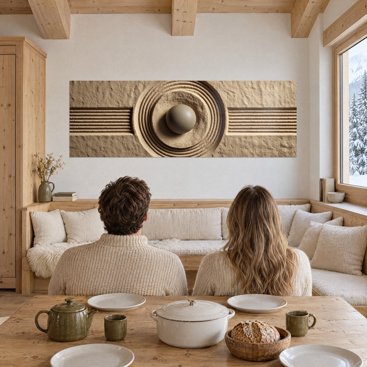 Quadro sfera di pietra grigia al centro di anelli cesellati, sabbia color crema striata, una coppia di spalle accanto a un tavolo in legno