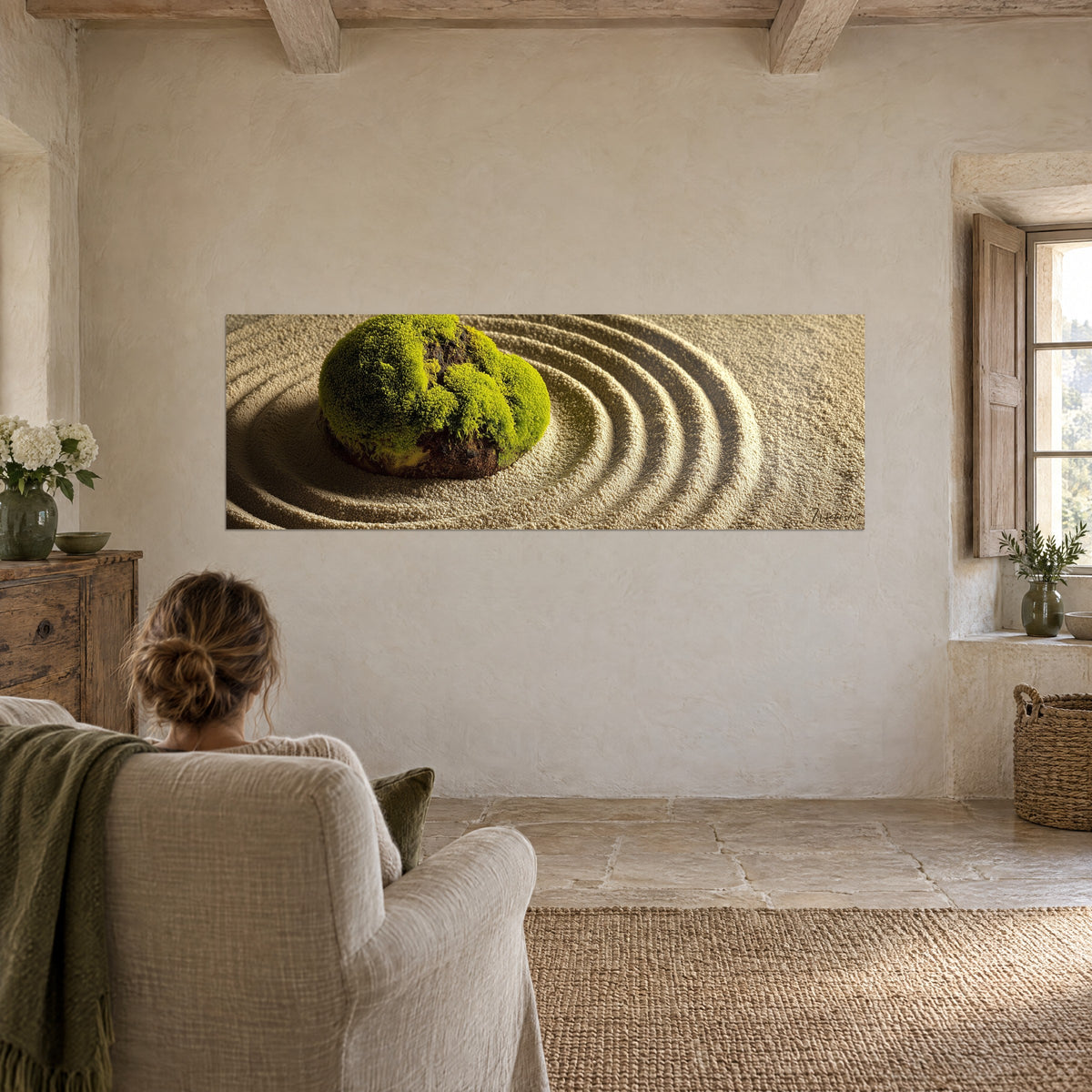 Tableau îlot de mousse vert pomme dans des vagues de sable beige, mur chaulé, femme de dos dans un fauteuil de lin