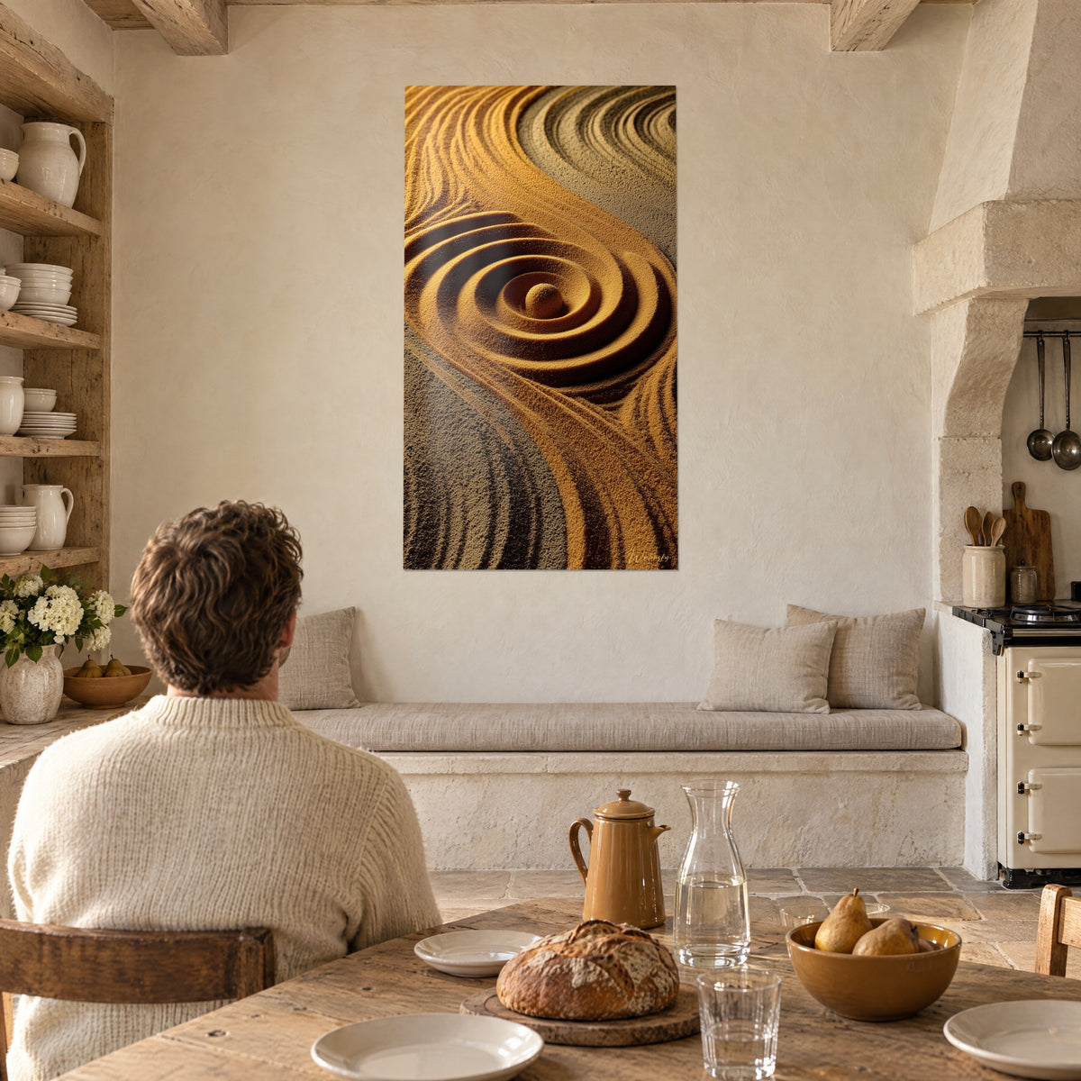 Quadro vortici concentrici di sabbia miele e marrone scuro, di fronte a un tavolo da cucina rustico in pietra