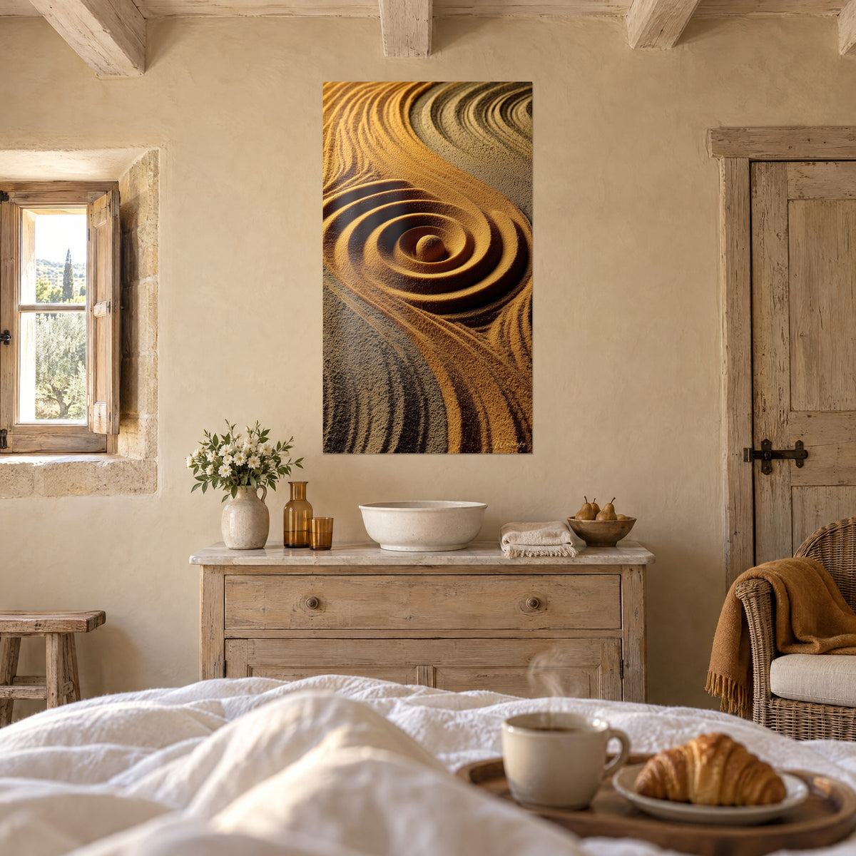 Quadro giardino zen di sabbia, onde ocra e grigio antracite attorno a un ciottolo, sopra un letto in una camera luminosa