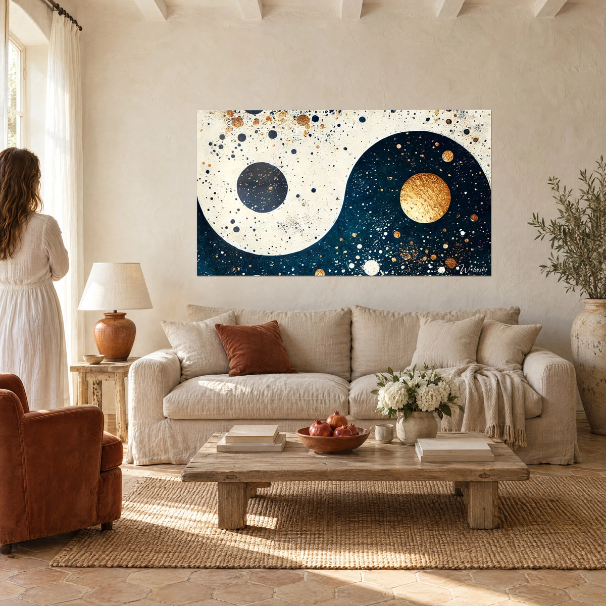 Tableau symbole yin yang crème et bleu nuit, planètes dorées, une femme de dos, au-dessus d'un canapé dans un salon lumineux