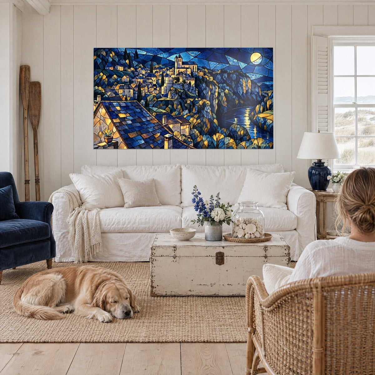 Gemälde Dorf auf dem Felsen im blau-goldenen Glasfenster-Stil unter dem Mond, über einem Sofa in einem hellen Wohnzimmer