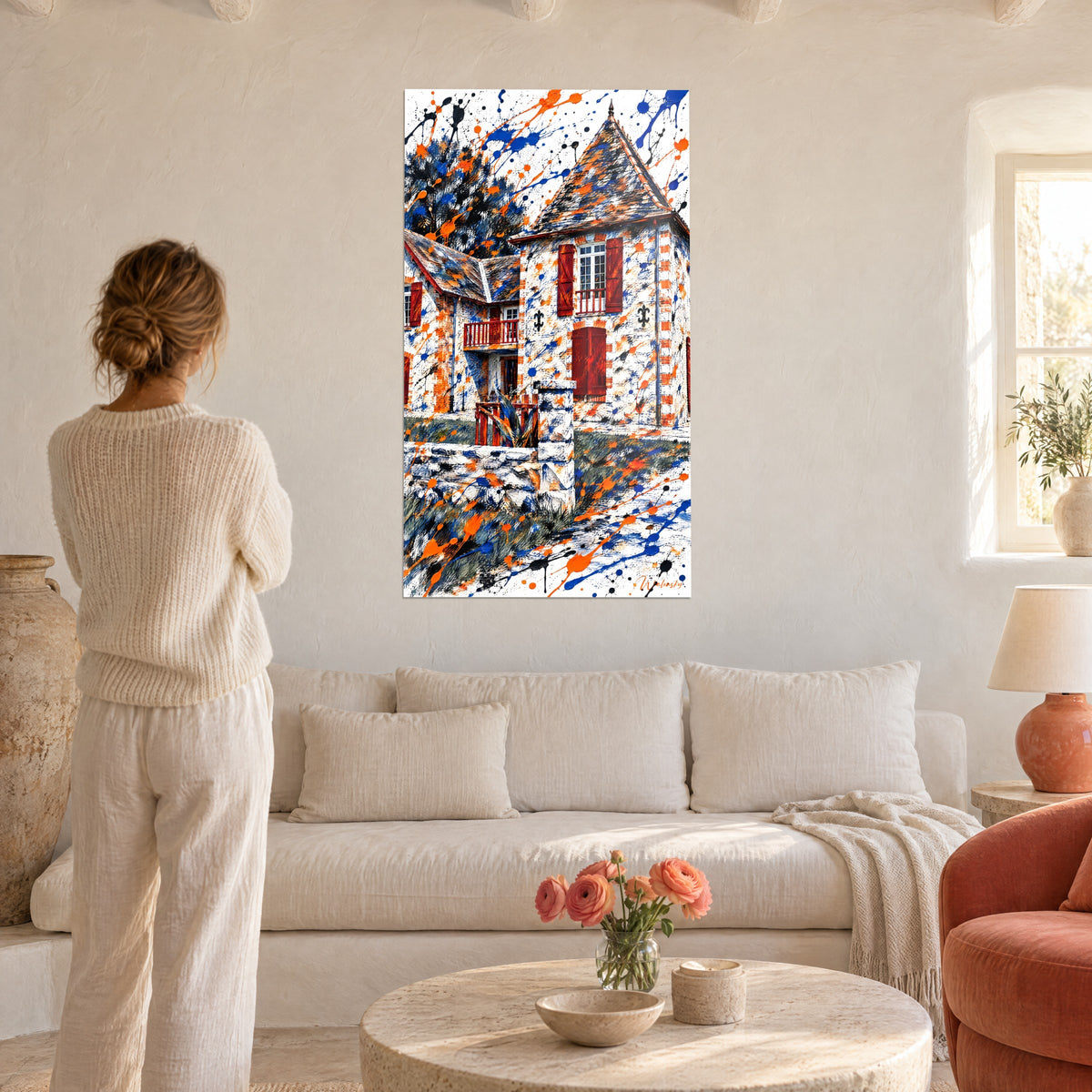 Schilderij herenhuis met torentje en rode luiken, oranje en marineblauwe spatten, boven een bank in een lichte woonkamer