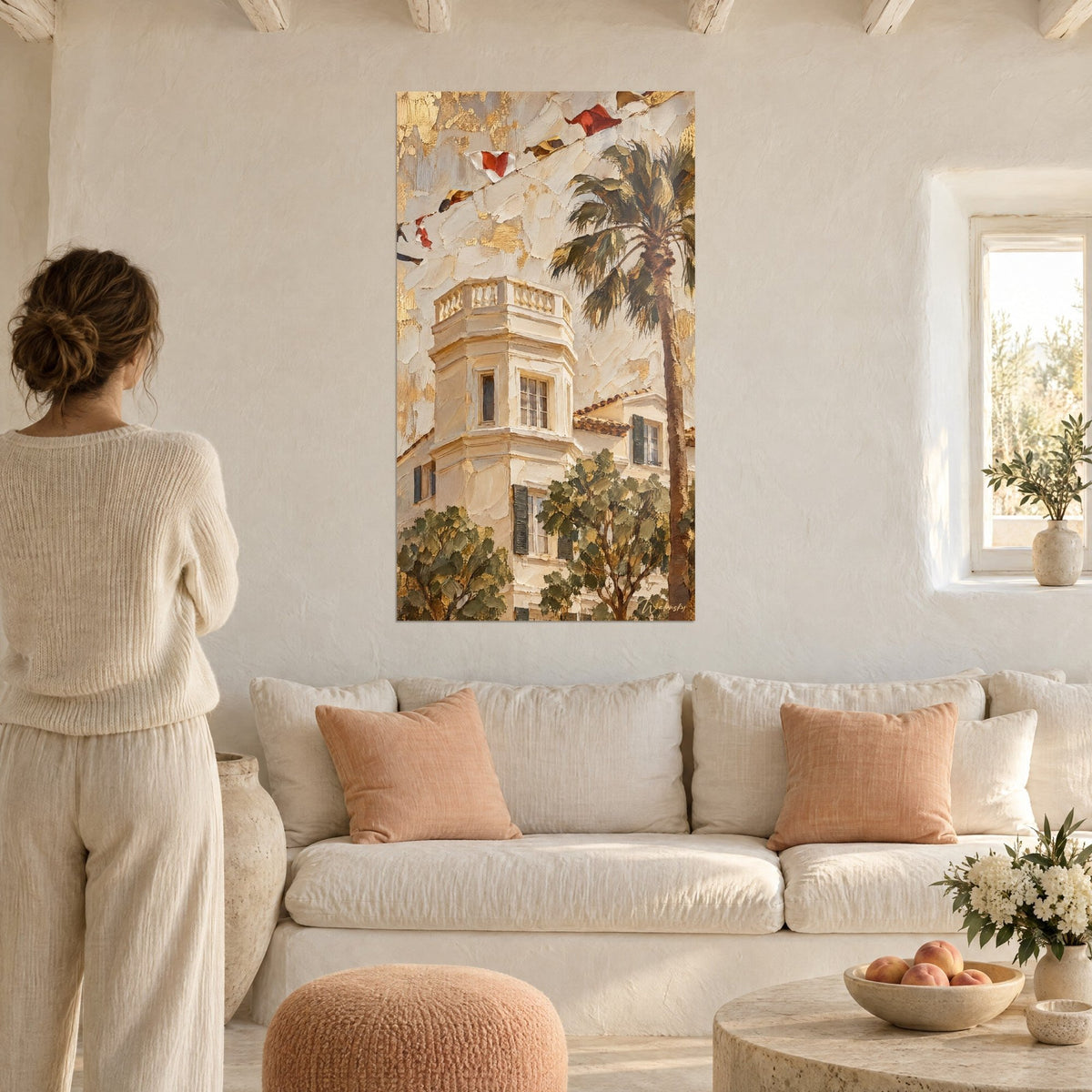 Wall art golden villa with cream turret, ochre palm and anthracite shutters, woman seen from behind, above a sofa in a bright living room