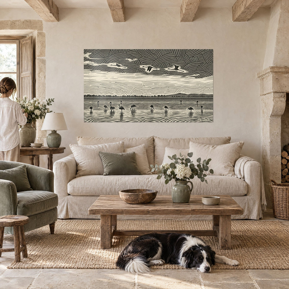 Wall art of flamingos in black and cream linocut over a lagoon, a reclining collie, above a sofa in a bright living room
