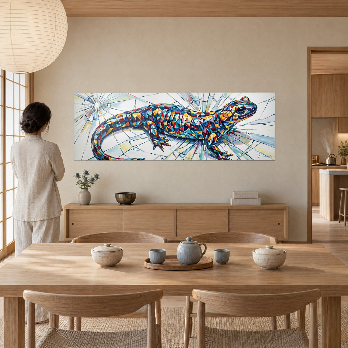 Tableau reptile en mosaïque orange et bleu nuit, bouche sombre ouverte sur un mur beige, vu de dos près d'une table en bois