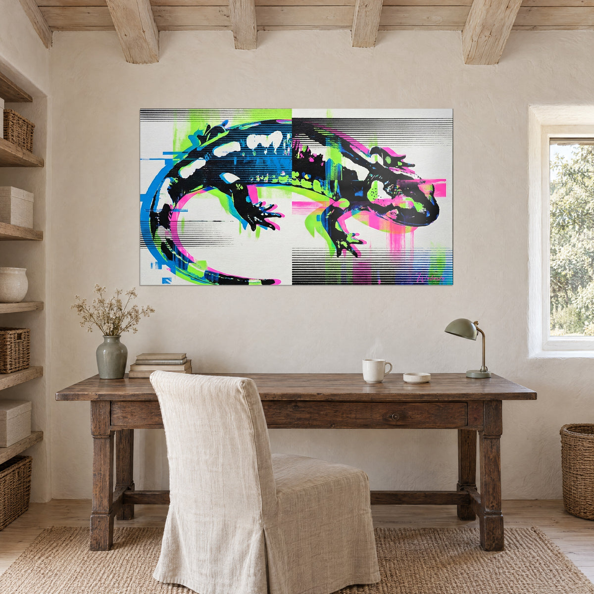 Wall art graphic black and white amphibian, pink drips and blue strokes, hung on an ochre stone wall above a rustic wooden desk