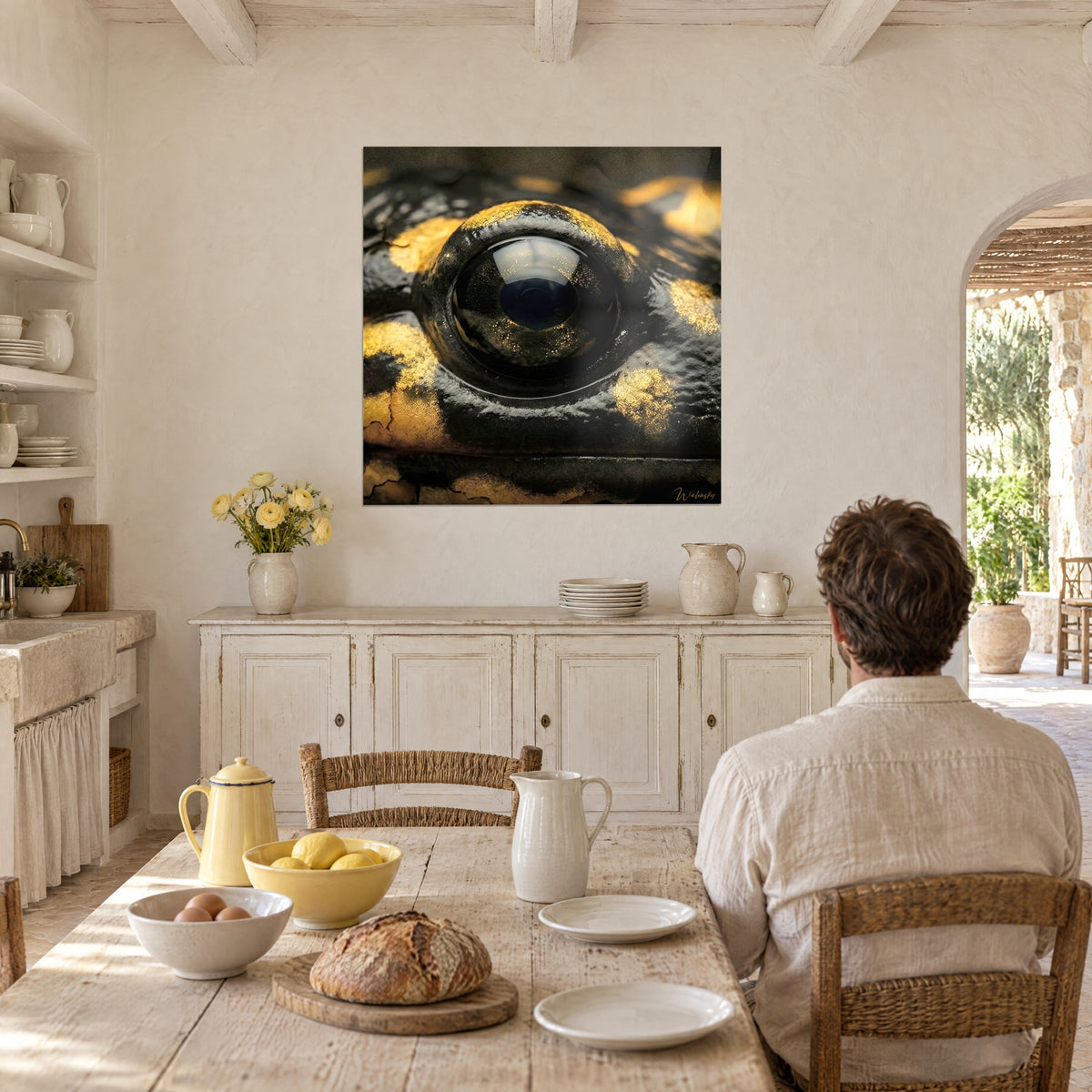 Wall art amphibian in macro, golden highlights on dark leather and an ink-black pupil, man seen from behind at a table, bread and a yellow teapot, farmhouse dining room