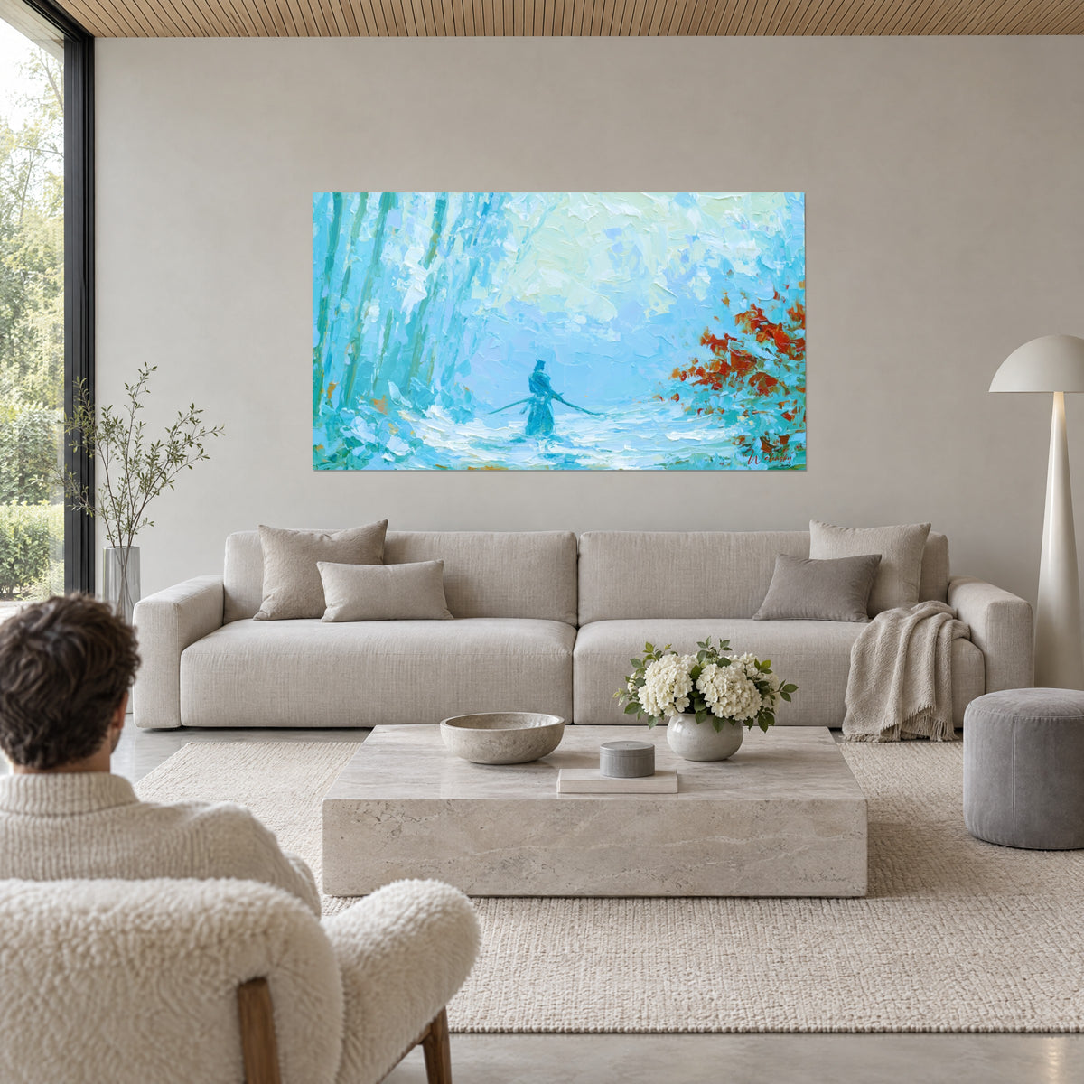 Tableau samouraï turquoise dans la brume, feuillage roux à droite, une personne de dos, au-dessus d'un canapé dans un salon lumineux