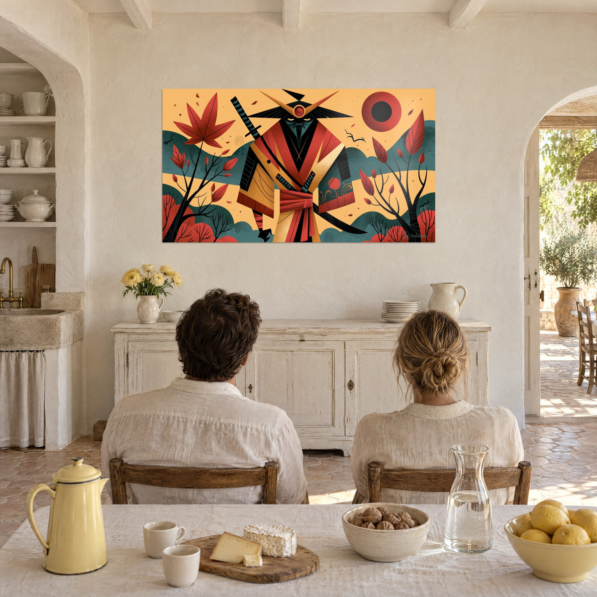 Wall art of a geometric samurai silhouette, black sword and red sun, facing a couple seated at the table of a Provençal farmhouse