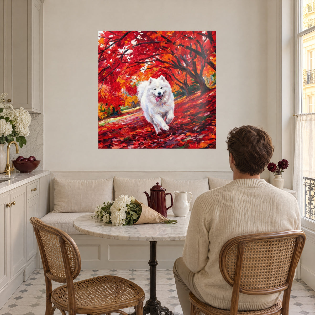Quadro di un samoiedo sorridente con la lingua rosa fuori tra fogliame rosso e arancio, uomo di spalle, vicino a una cucina luminosa