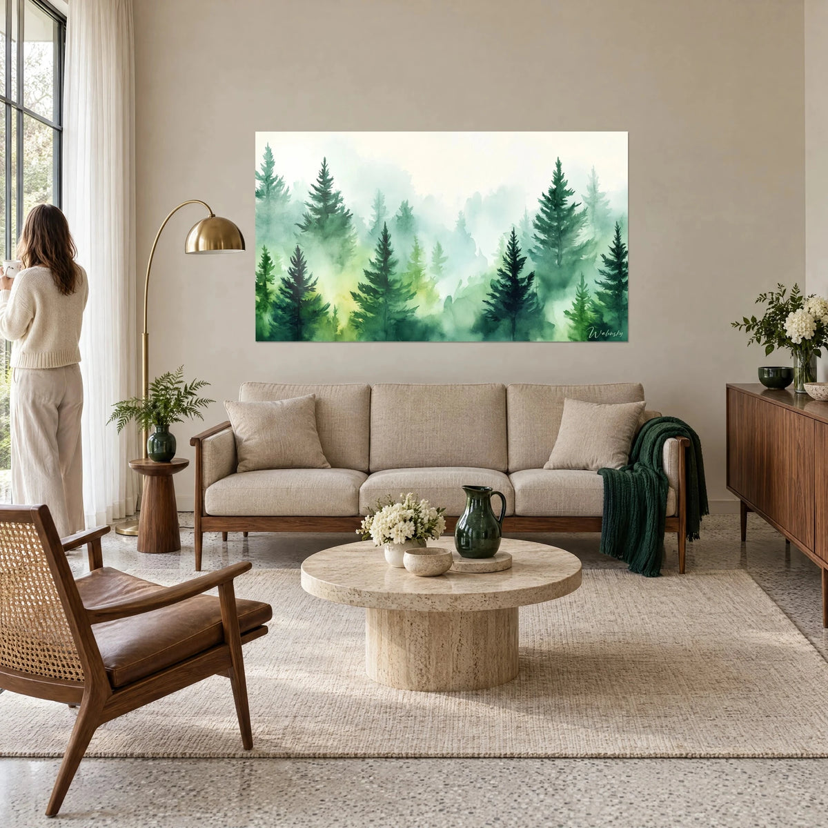 Tableau forêt de sapins dans la brume, verts profonds et jaune tendre, une femme de dos, au-dessus d'un canapé dans un salon lumineux