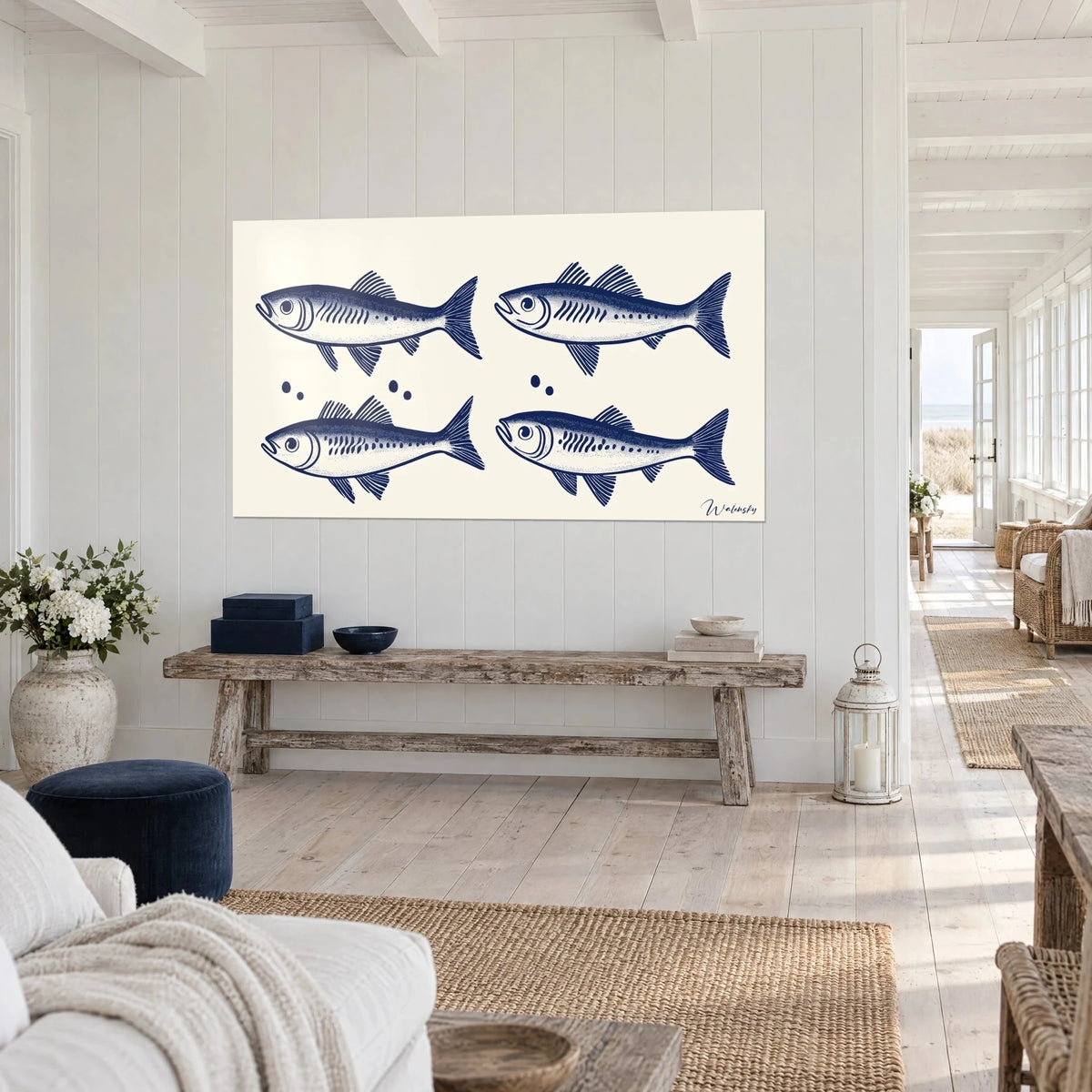 Wall art quartet of indigo fish with striped fins on ivory background, white slatted wall, rustic wooden bench, seaside house