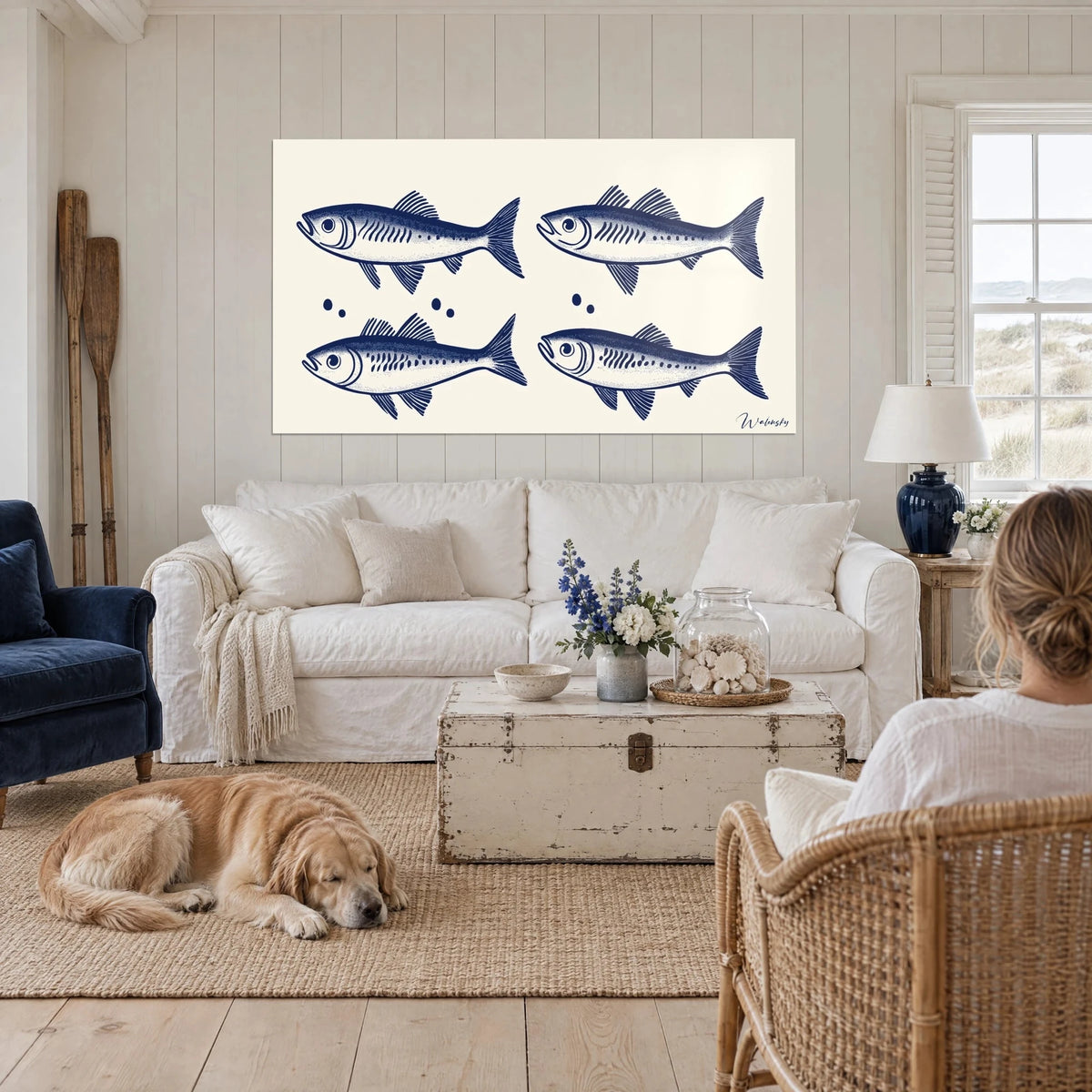Wall art navy blue sardine shoal on cream background, four engraved fish, lying retriever, above a sofa in a bright living room