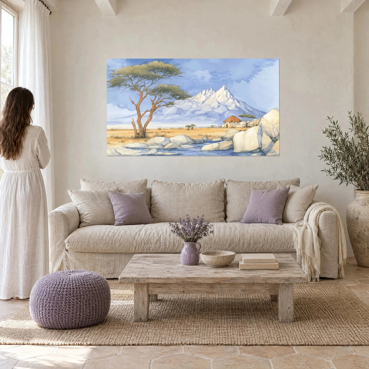 Wall art acacia with a copper-toned trunk facing snowy Mount Kilimanjaro, lavender blue sky, ochre savanna, hung above a sofa in a bright living room
