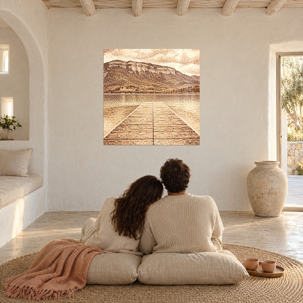 Cuadro perspectiva de un muelle rubio sobre un lago espejo, acantilado pardo rojizo y cielo beige, en la pared de un salón abovedado blanco