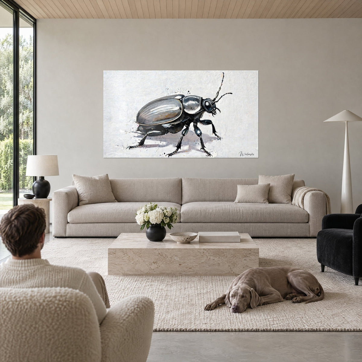 Wall art black beetle with silvery grey wing cases, mauve shadow on white background, above a sofa in a bright living room