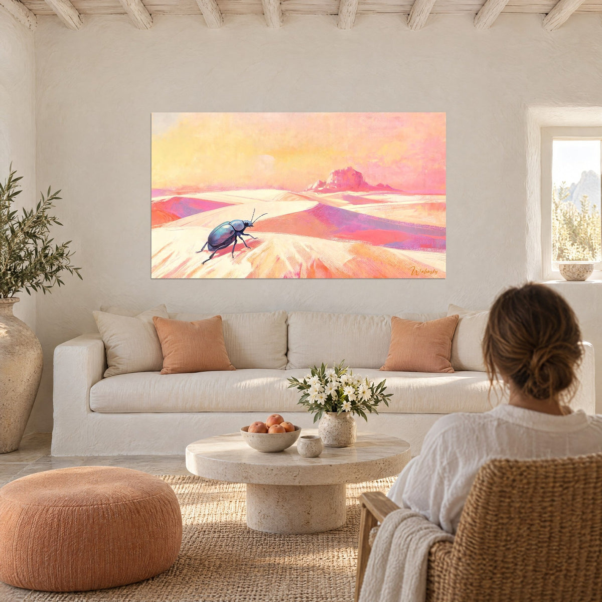 Quadro di uno scarabeo blu metallizzato su dune rosa e gialle, mesa lontana, sopra un divano in un soggiorno luminoso