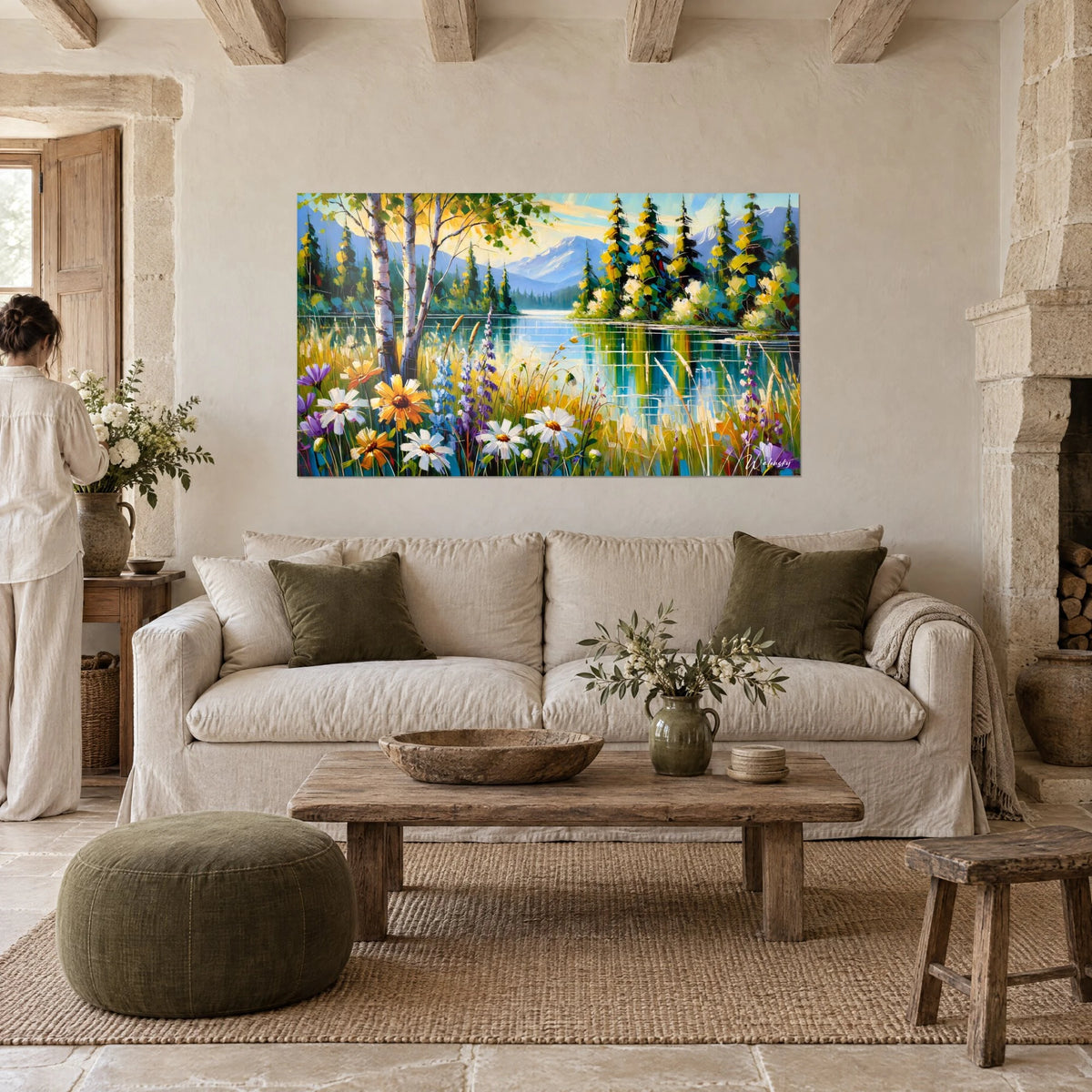 Wall art turquoise blue mountain lake bordered by white daisies, two people seen from behind above a sofa in a bright living room