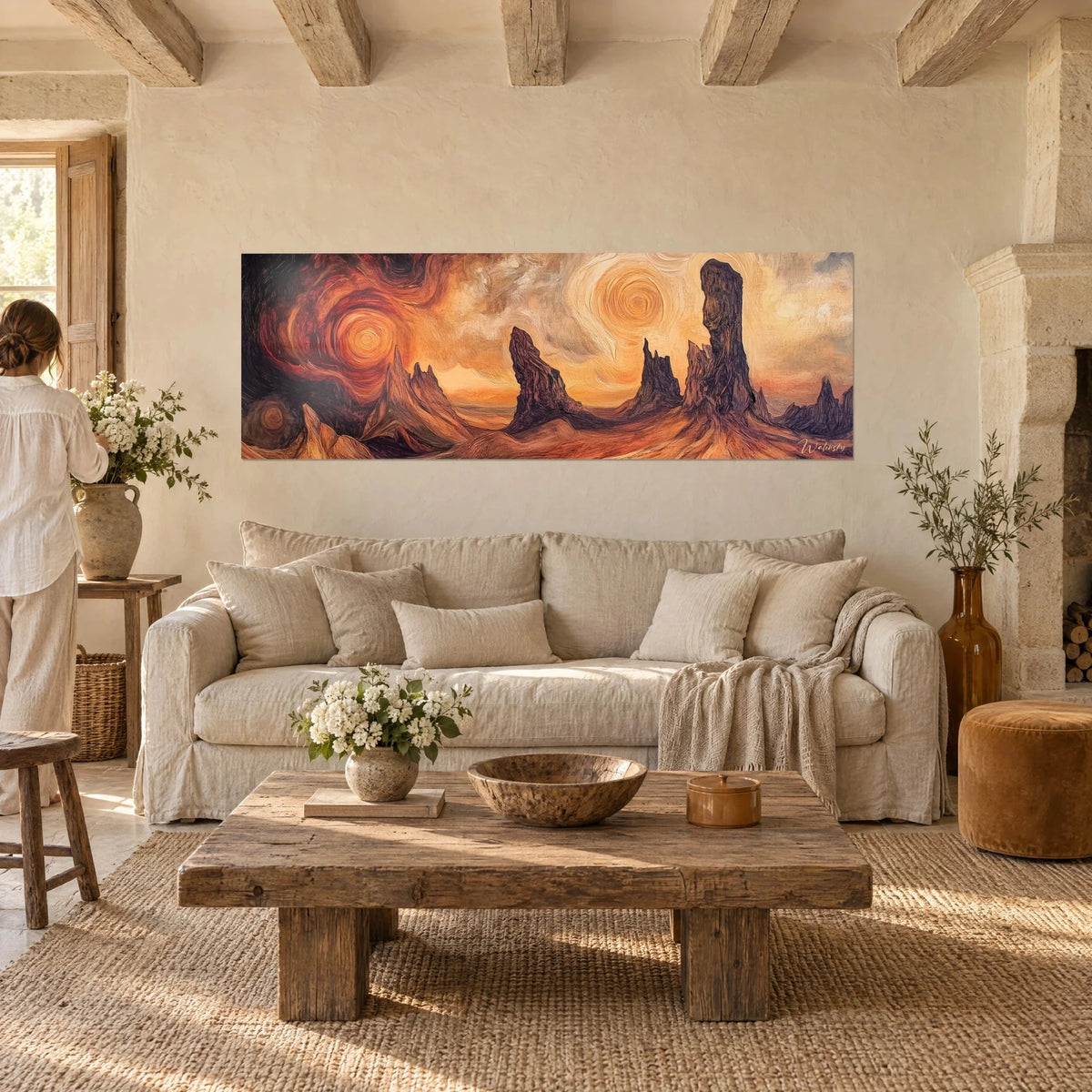 Wall art of sculpted rock monoliths under a spiraling orange and crimson sun, above a sofa in a bright living room