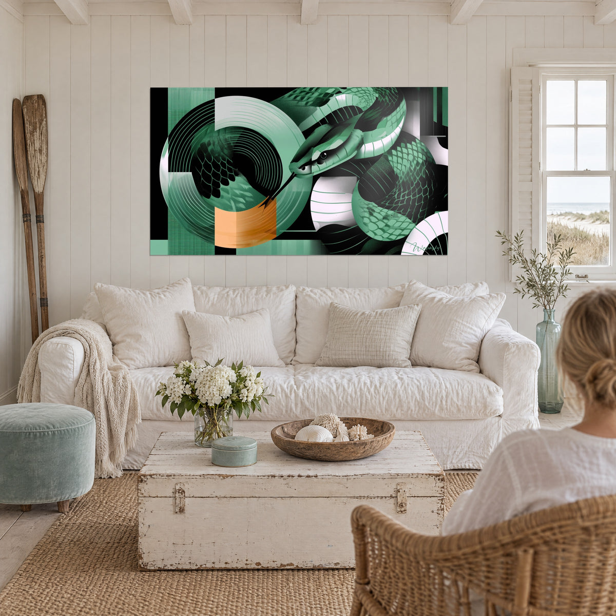 Tableau serpent émeraude lové autour de disques de vinyle, noir et vert sauge, au-dessus d'un canapé dans un salon lumineux