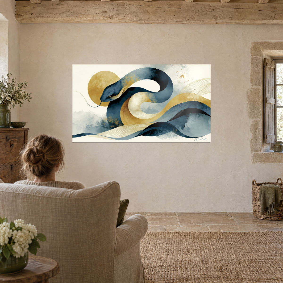 Tableau spirale de serpent bleu marine et or vieilli, œil ambré, face à un fauteuil en lin, mur chaulé de pierre