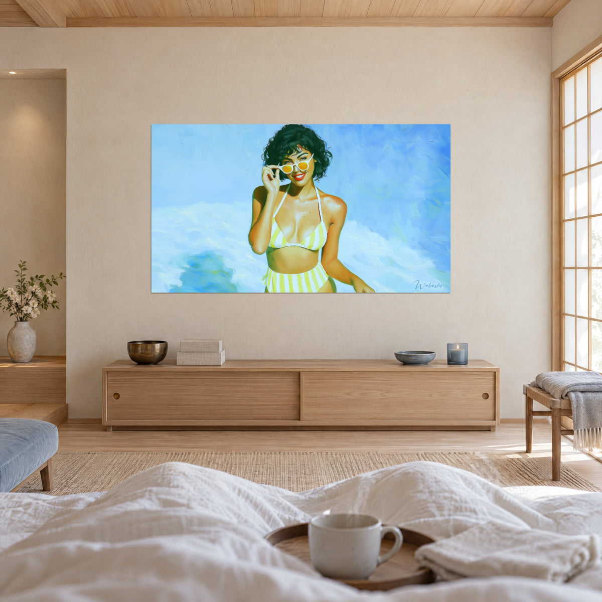 Wall art laughing portrait of a bather with red lips, yellow and white striped bikini, blue sky, above a bed in a light bedroom