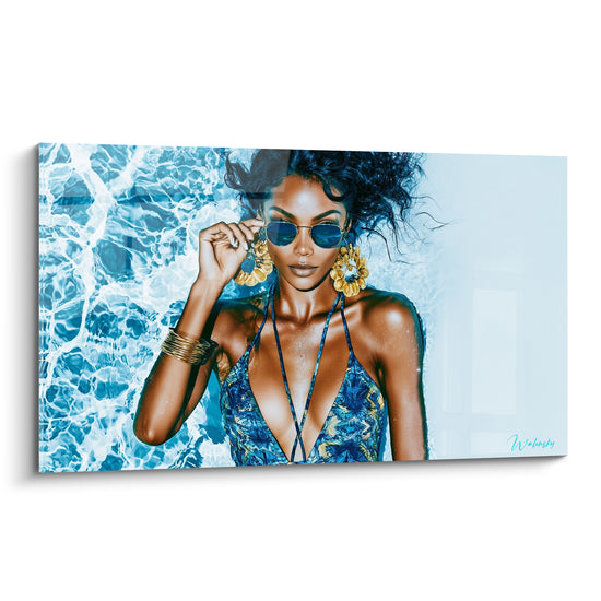 Femme aux cheveux bouclés porte des lunettes bleu turquoise et bijoux dorés dans l'eau