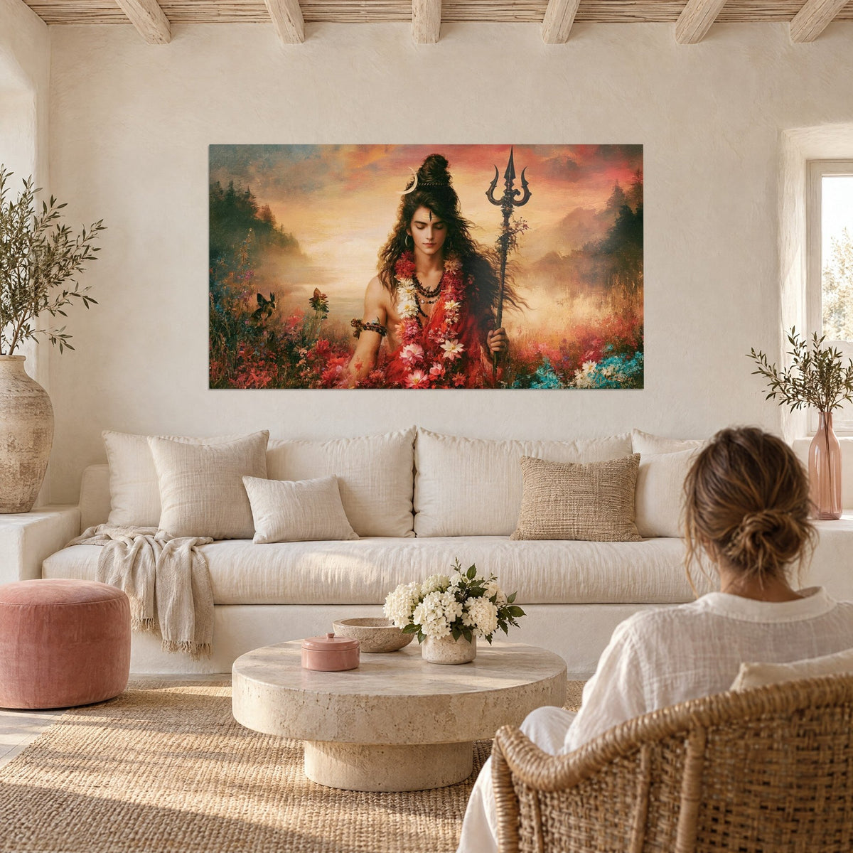 Tableau divinité fleurie au trident sombre, guirlandes rouges et blanches, ciel orangé, au-dessus d'un canapé dans un salon lumineux
