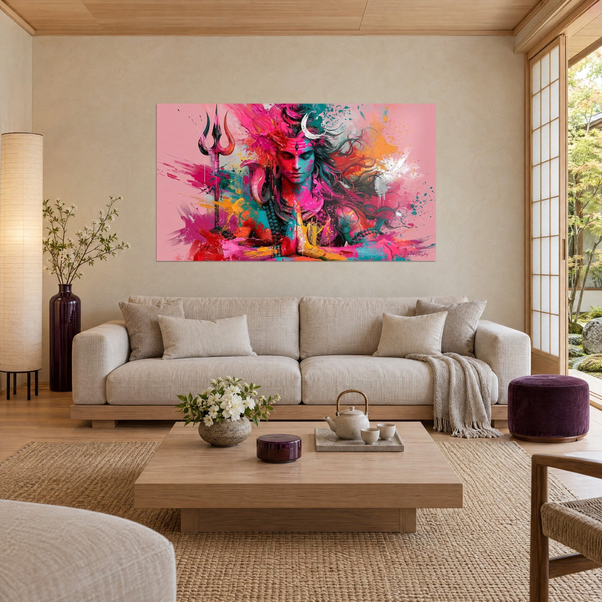 Wall art of Shiva with closed eyes and hands pressed together, pink and turquoise face, trident on a pink background, above a sofa in a bright living room
