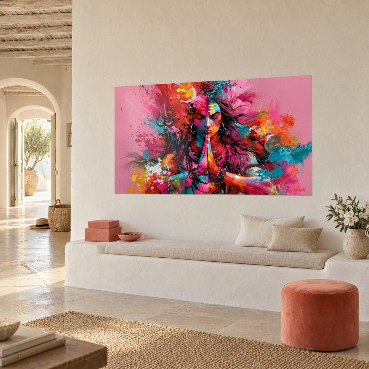 Cuadro de Shiva con los párpados cerrados, salpicaduras naranjas y magenta sobre fondo rosa, pared blanca de una casa mediterránea