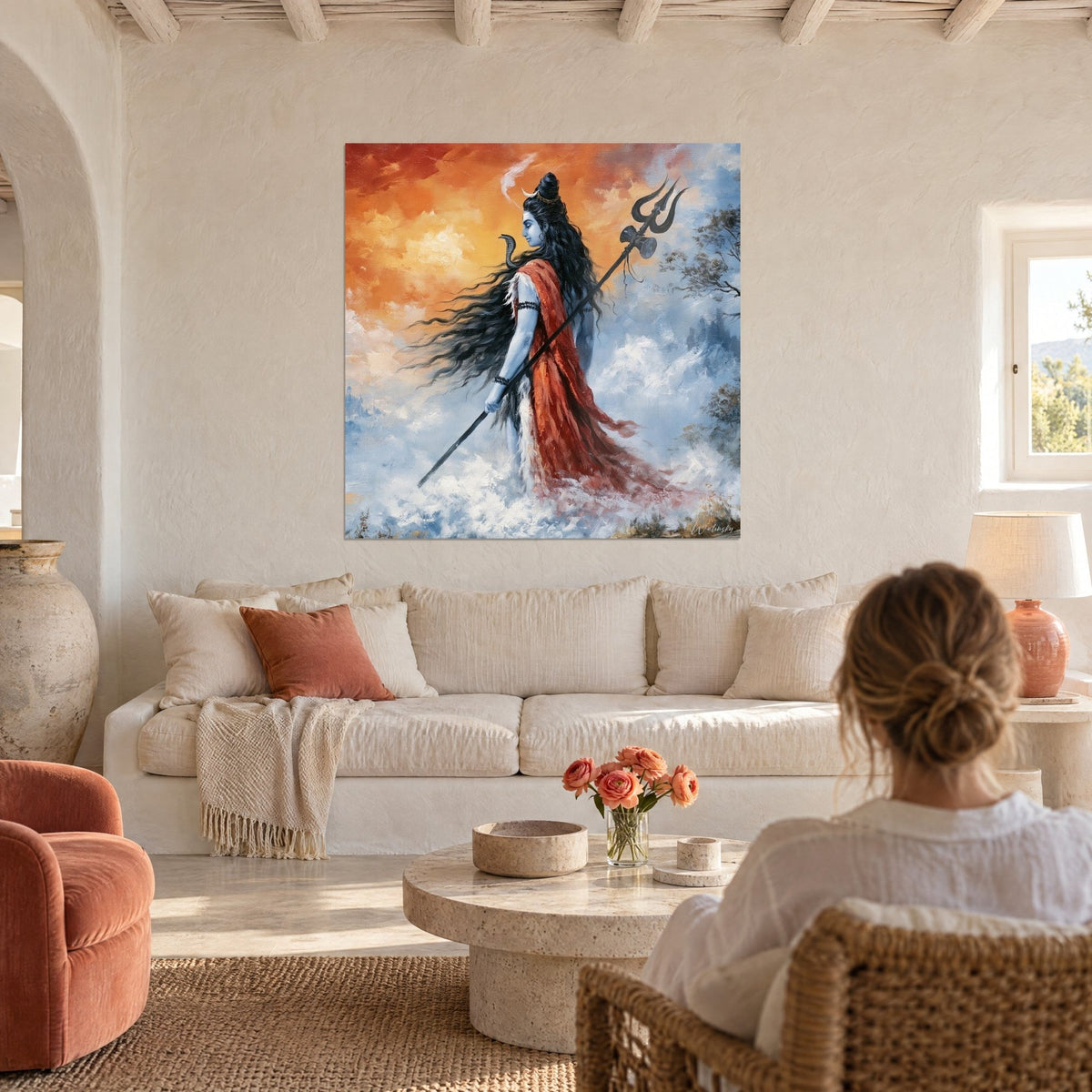 Tableau Shiva bleuté au trident noir, drapé rouge et long voile de cheveux, ciel orangé, au-dessus d'un canapé dans un salon lumineux