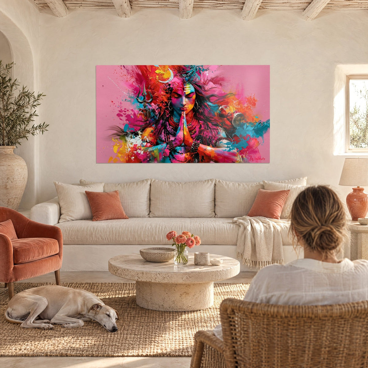 Cuadro de una deidad meditando con las manos juntas, rosa vivo y turquesa, encima de un sofá en un salón luminoso