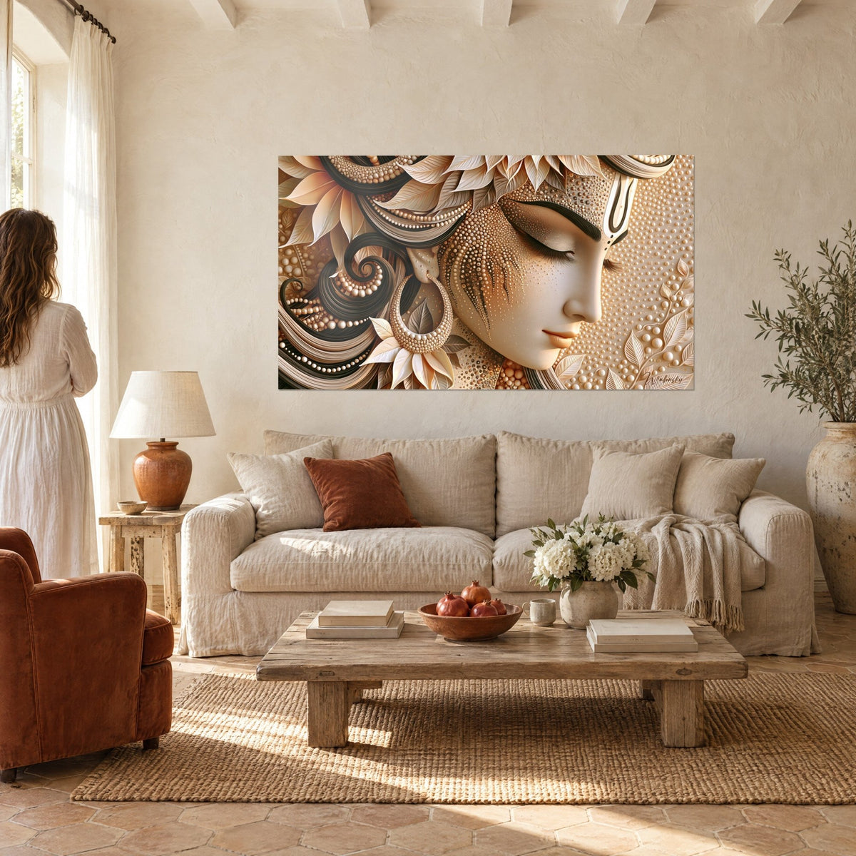 Wall art of a goddess face with closed eyelids, ivory pearls and brown curls, gilded, above a sofa in a bright living room