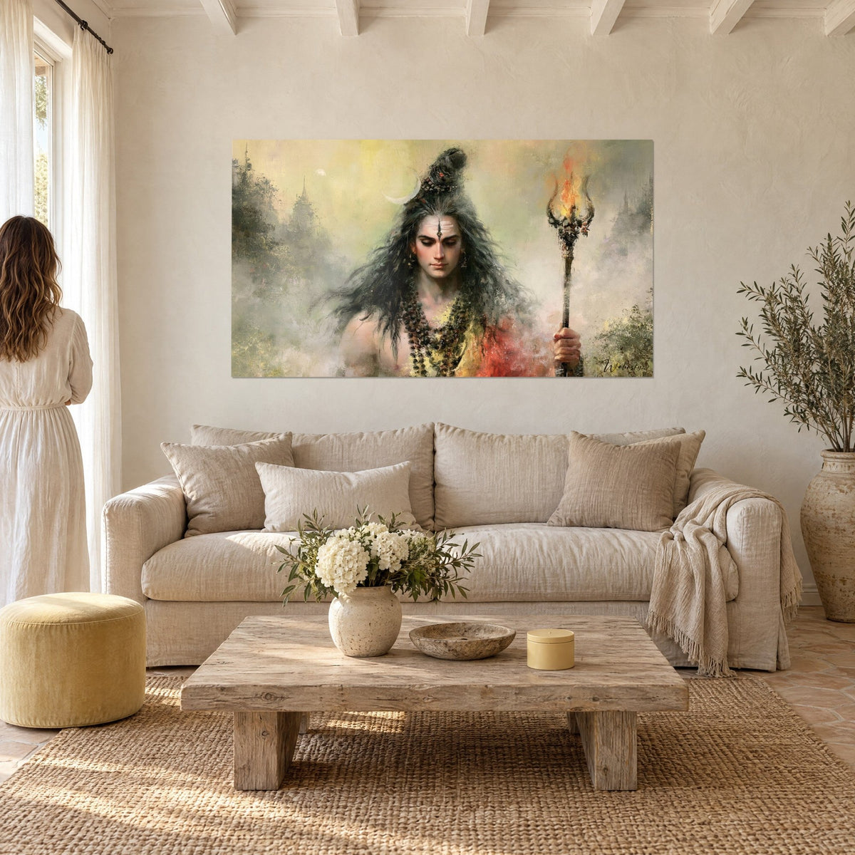 Wall art deity with black hair and crescent moon, ochre and grey trident, on a white wall above a sofa in a bright living room