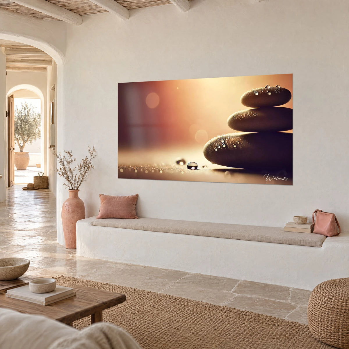 Schilderij evenwichtige zen-stenen met gouden reflecties en chocoladebruin, opgehangen aan een gekalkte muur naast een stenen bank