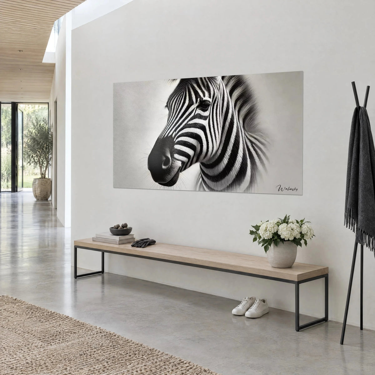 Wall art zebra head with black and white stripes on a pearl grey background, three-quarter view, wooden console and vase of white flowers in the entrance