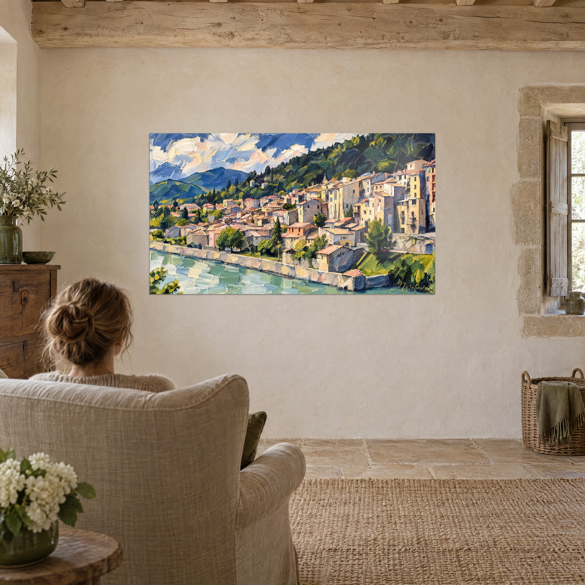 Cuadro Ciudad provenzal escalonada bajo un cielo azul y blanco, río esmeralda y tejados color óxido, frente a un sillón de lino