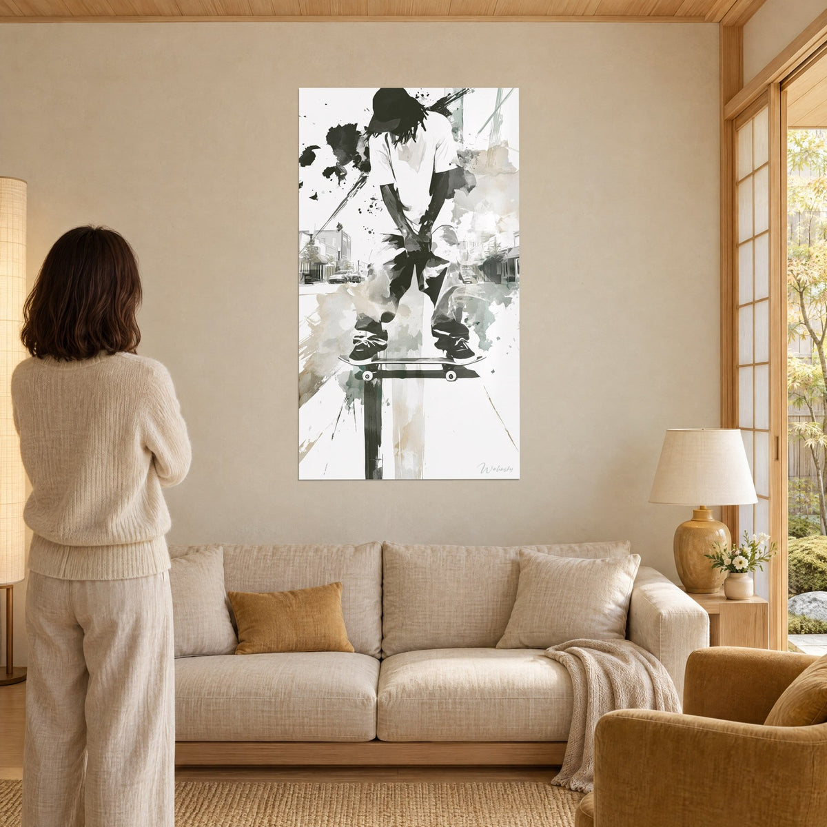 Wall art of a skater leaning forward, white t-shirt and black trousers, beige splashes, above a sofa in a bright living room