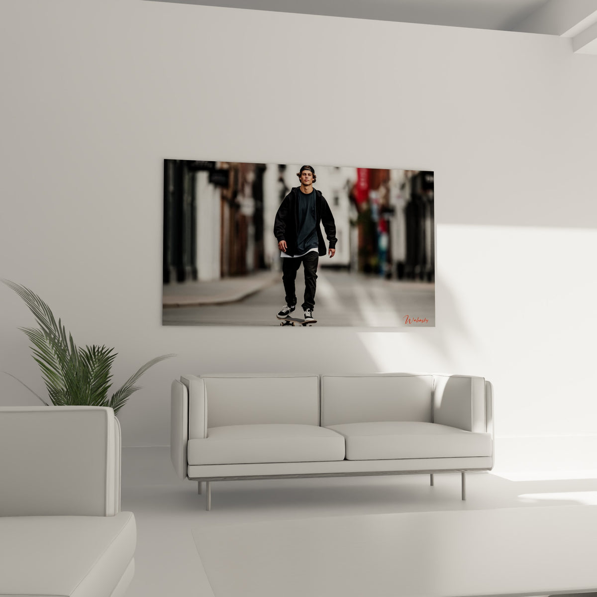 Jeune homme en noir sur skateboard, façade blanche et grise en arrière-plan, au-dessus d'un canapé dans un salon lumineux