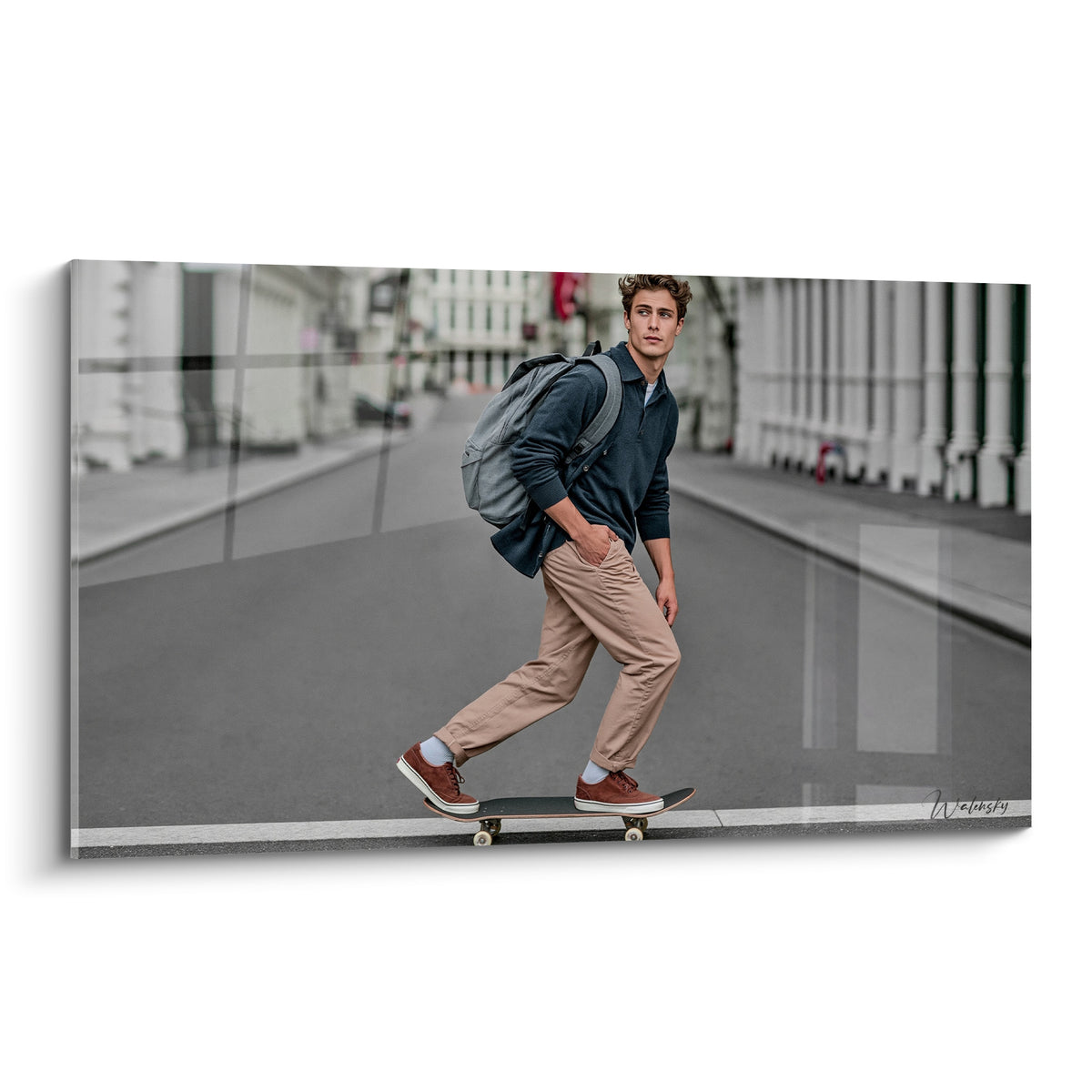 Skateur en veste bleu marine et pantalon beige traversant une rue en noir et blanc