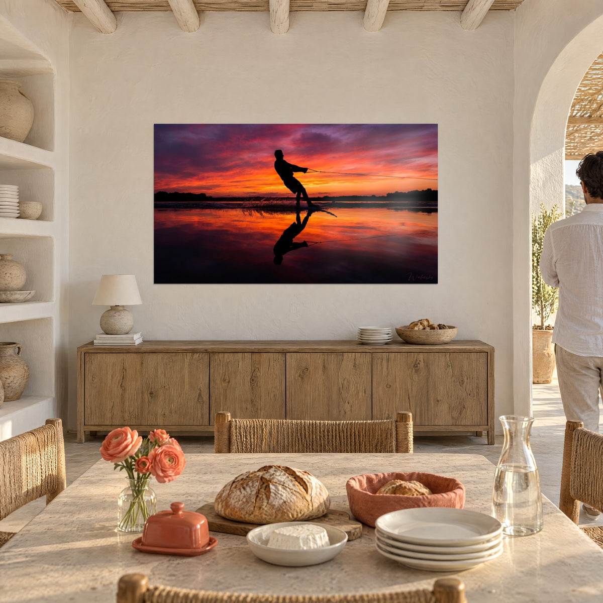 Quadro ombra di uno sciatore che scivola in controluce, cielo fiammeggiante rosso e dorato, credenza in legno e arco bianco di una casa