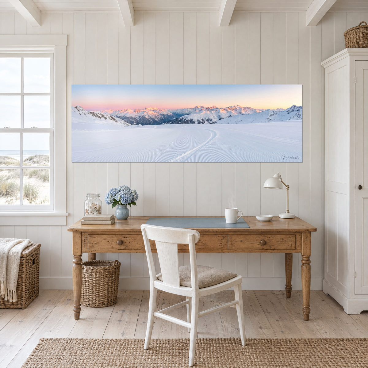 Wall art frosted alpine range in the rising sun, pastel pink and light blue, hung above a wooden desk near a window