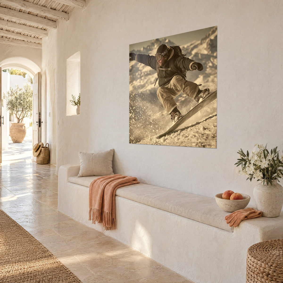 Wall art of a freerider carving a turn, board tilted, ochre spray of snow and beige pants, on a white wall above a bench in pale stone
