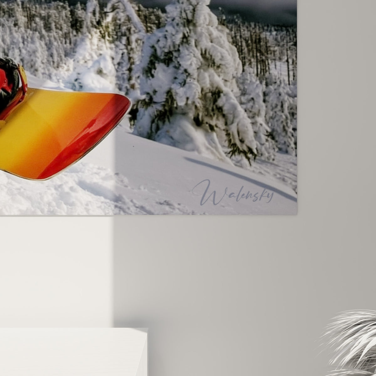 Détail de la matière : grains de poudre violette et jaune éclatant sur la planche orange du snowboardeur