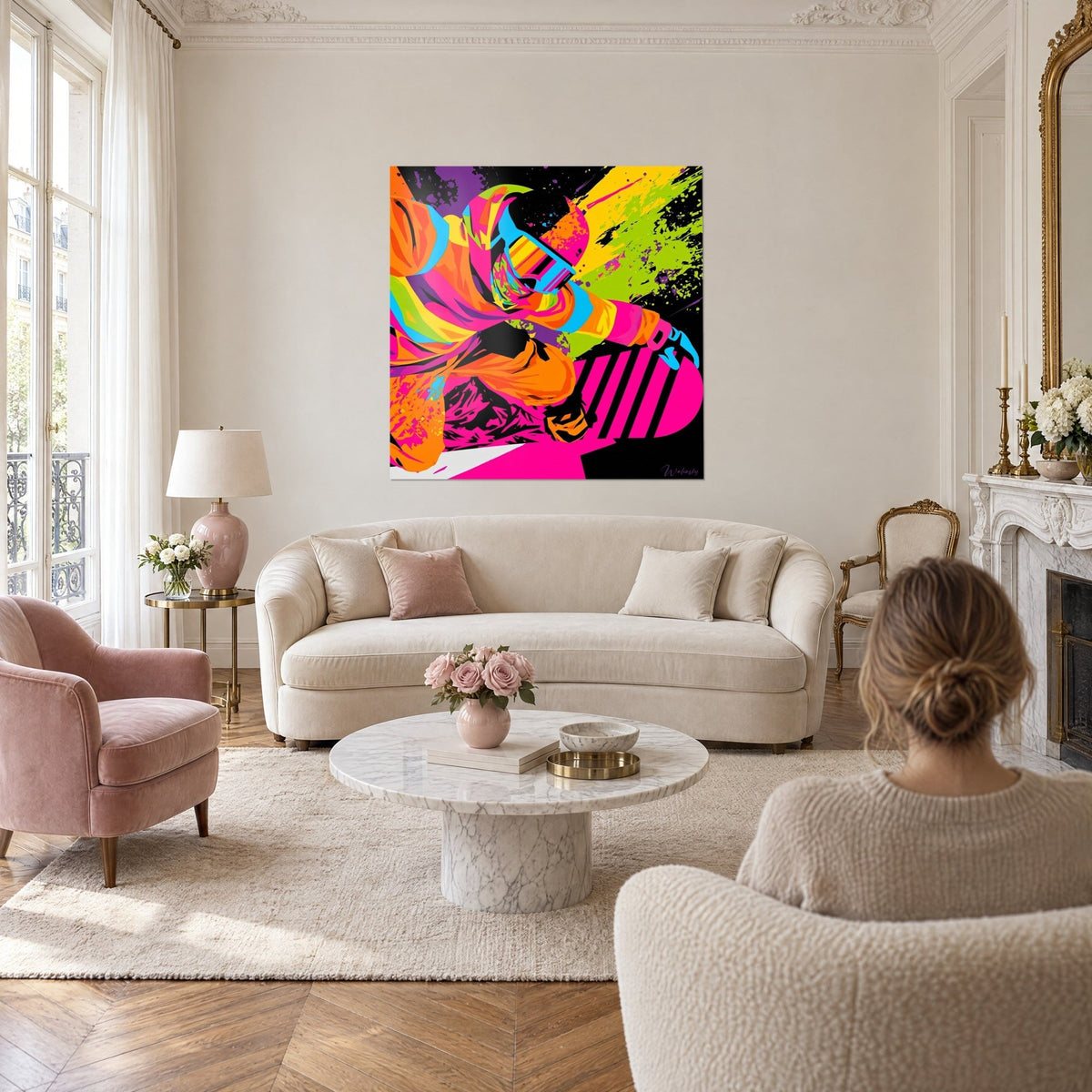 Tableau snowboardeur casqué en veste orange et rose fluo, éclaboussures vert anis, au-dessus d'un canapé dans un salon lumineux