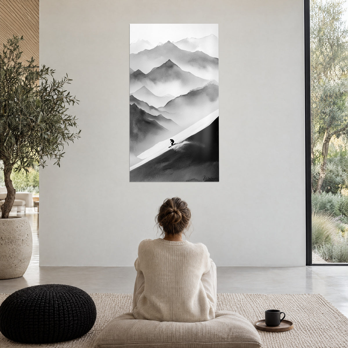 Wall art of misty black and white slopes, rider carving a spray of snow, admired by a woman seated on a pouf