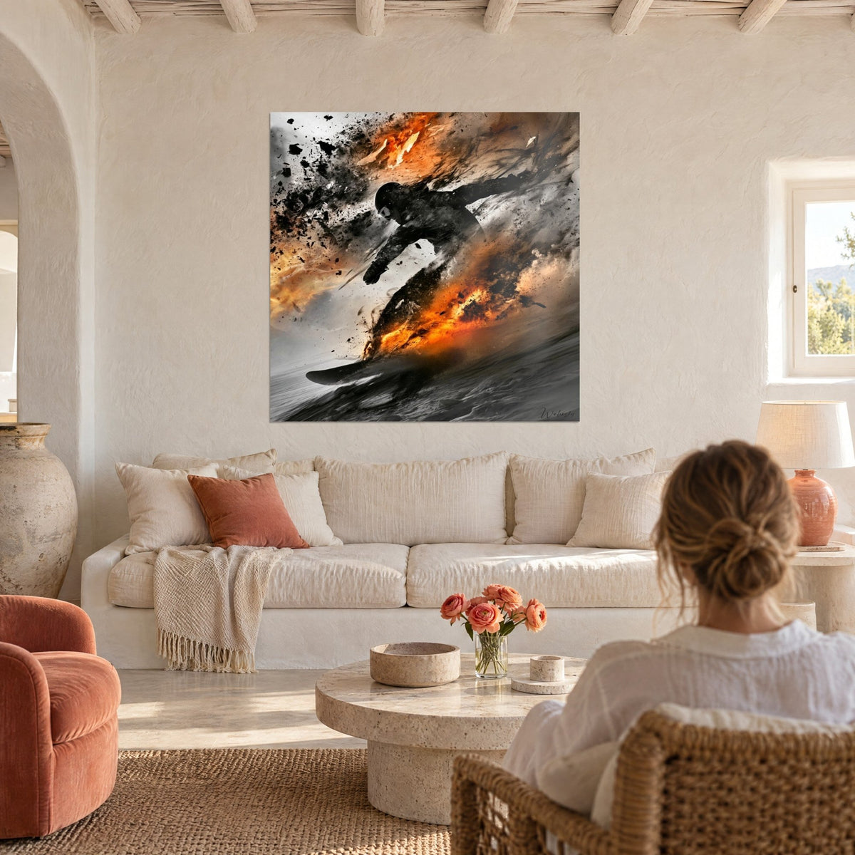 Wall art of a snowboarder in black silhouette slicing through bursts of orange flames and grey snow, above a sofa in a bright living room