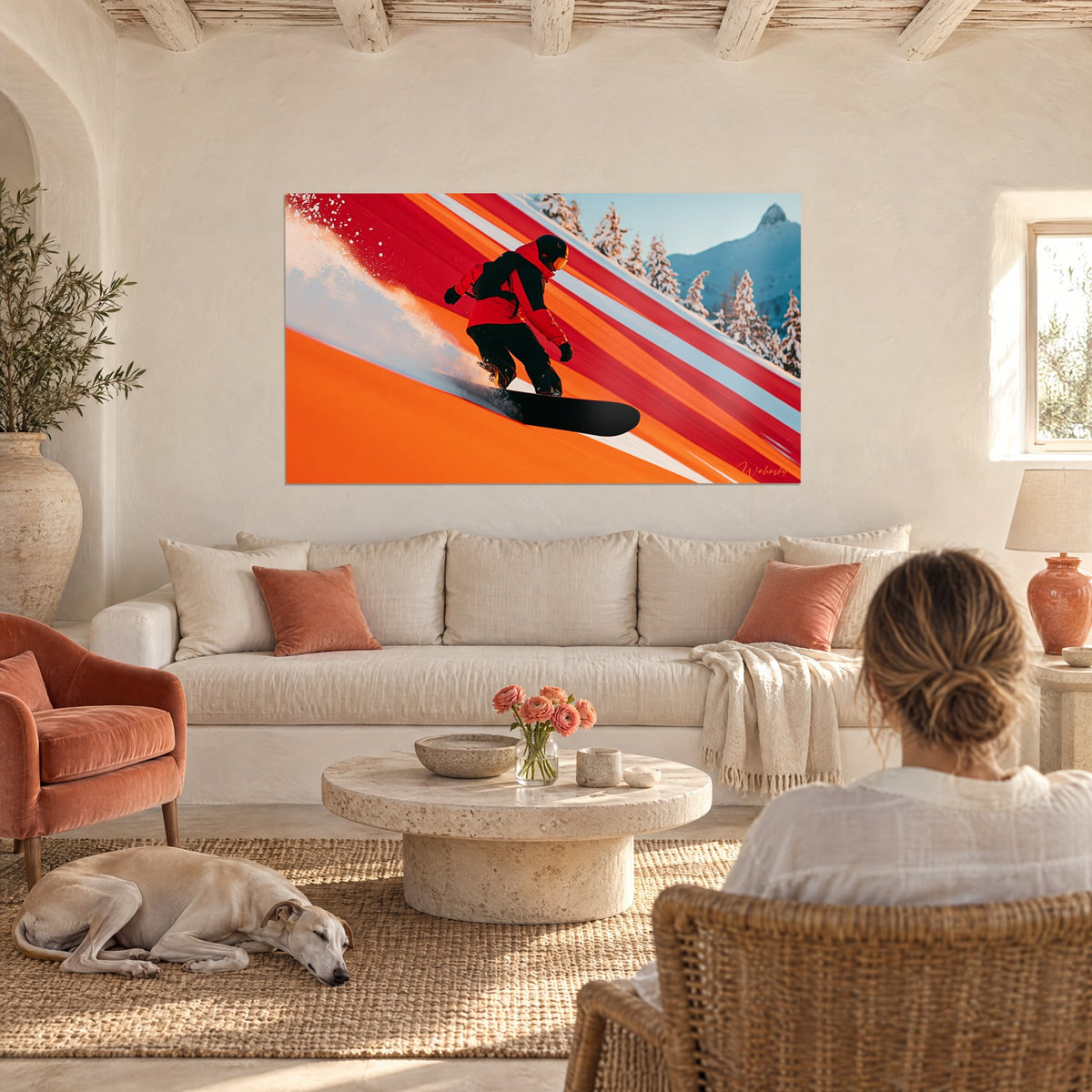 Cuadro de un snowboarder con chaqueta roja levantando una estela de nieve en una pista naranja, sobre un sofá en un salón luminoso