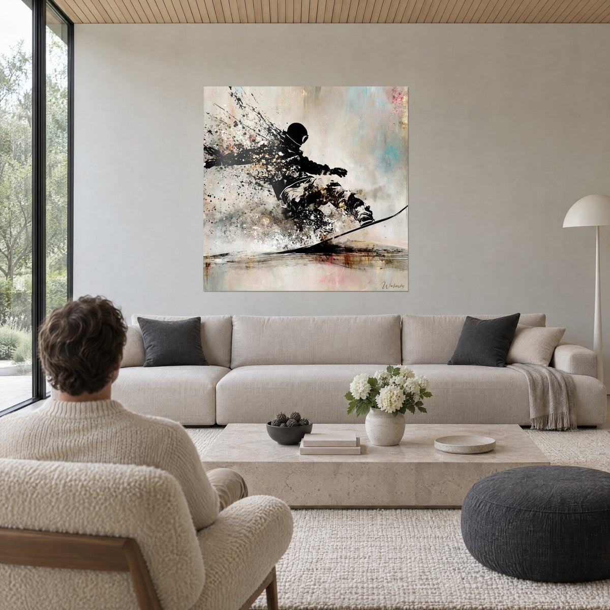 Quadro rider nero in silhouette, scia di polvere di neve beige e oro, sfondo azzurrato, uomo di spalle sopra un divano in un soggiorno luminoso